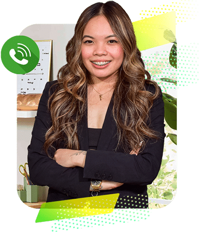  Woman with long wavy hair wearing a black blazer, smiling confidently with arms crossed. A green phone call icon is displayed in the upper left corner, suggesting availability or contact option.